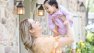 Mother holding young child in the air